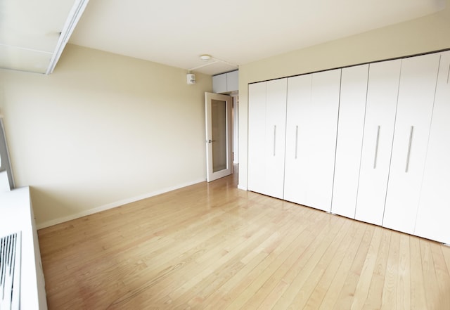 unfurnished bedroom with light hardwood / wood-style floors and a closet