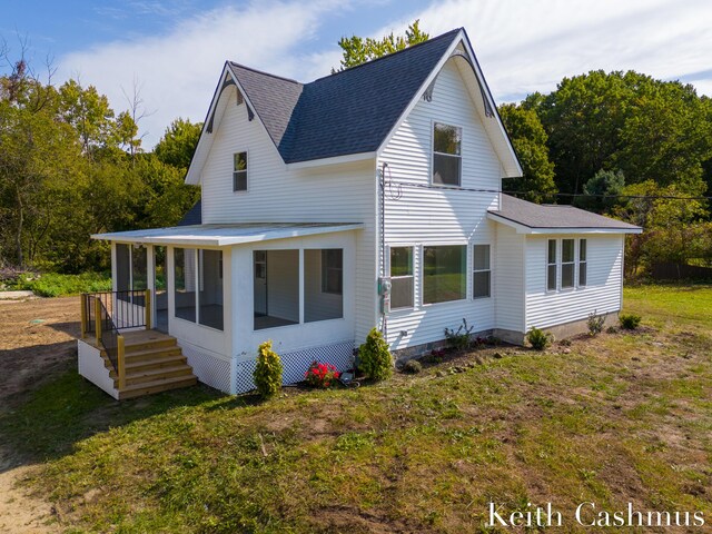 back of property featuring a sunroom and a yard