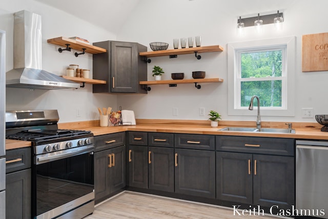 17513 M 140th Hwy, South Haven, MI 49090 - kitchen with appliances with stainless steel finishes, wall chimney exhaust hood, open shelves, a sink, and wooden counters