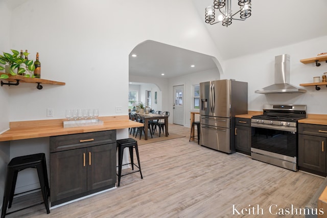 17513 M 140th Hwy, South Haven, MI 49090 - kitchen with stainless steel appliances, wall chimney exhaust hood, open shelves, wood counters, and a kitchen breakfast bar