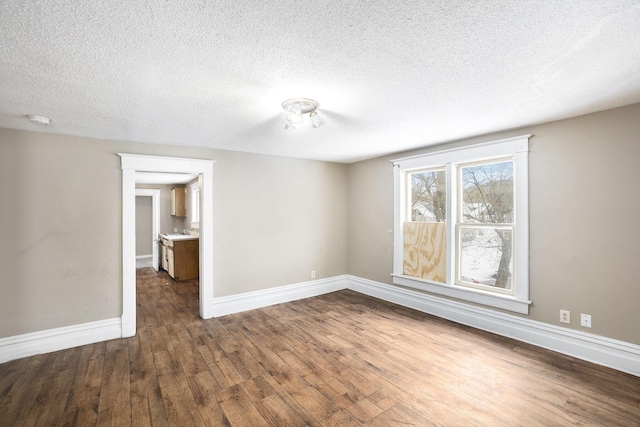 unfurnished room with a textured ceiling and dark hardwood / wood-style floors