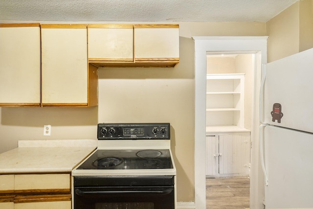 kitchen featuring light wood-type flooring, white appliances, and a textured ceiling