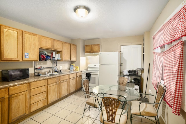 kitchen featuring a textured ceiling, white appliances, sink, and light tile patterned floors