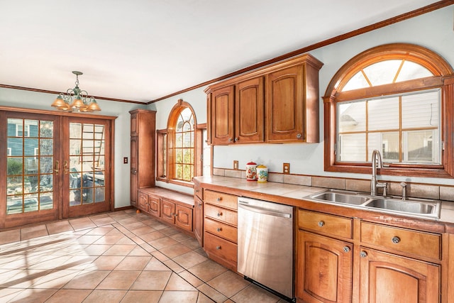 kitchen featuring sink, light tile patterned floors, dishwasher, a chandelier, and tile counters