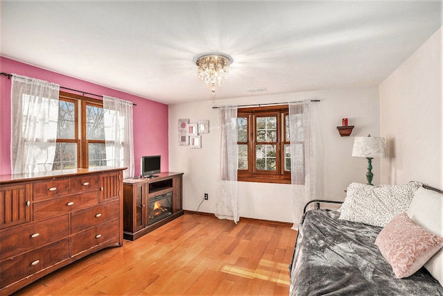 interior space featuring plenty of natural light, light hardwood / wood-style floors, and a notable chandelier