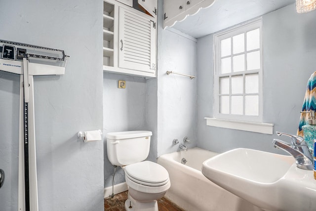 bathroom with sink, a bath, and toilet