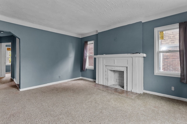 unfurnished living room featuring carpet and a wealth of natural light