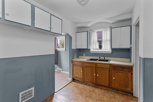 kitchen featuring white cabinetry and sink