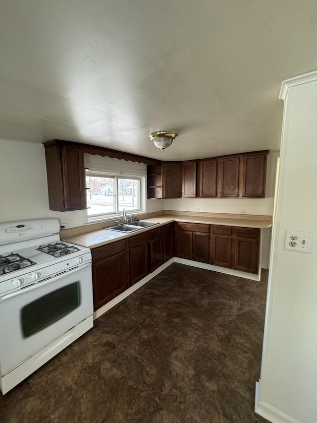 kitchen with dark brown cabinetry, white gas stove, and sink