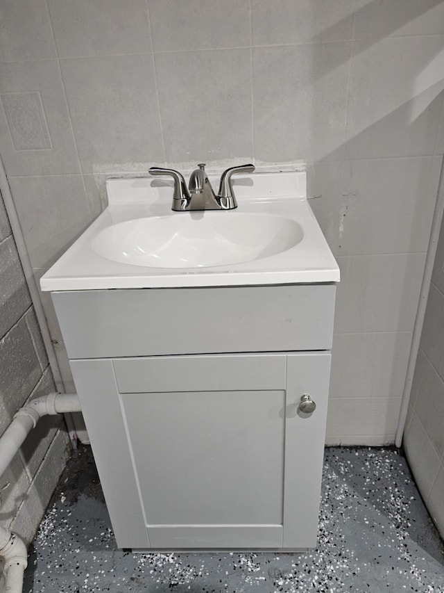 bathroom with vanity and tile walls