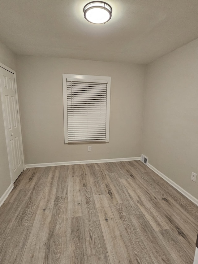 unfurnished room with light wood-type flooring