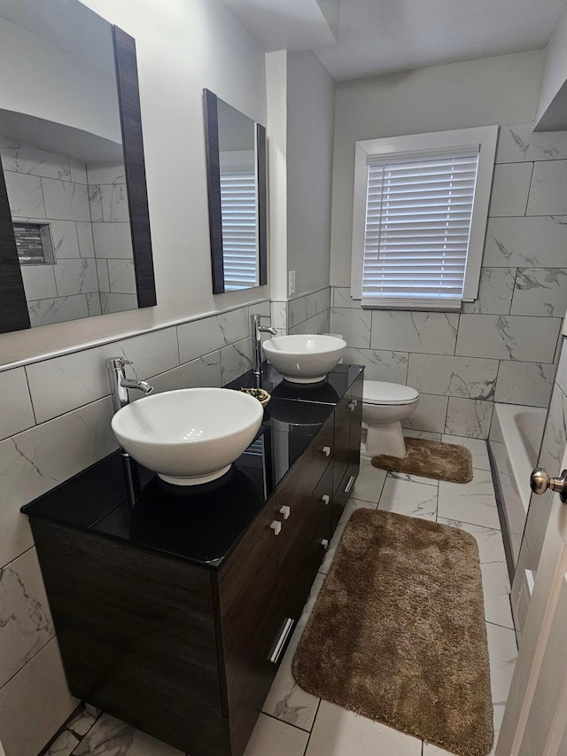 full bathroom with vanity, toilet, tile walls, and shower with separate bathtub