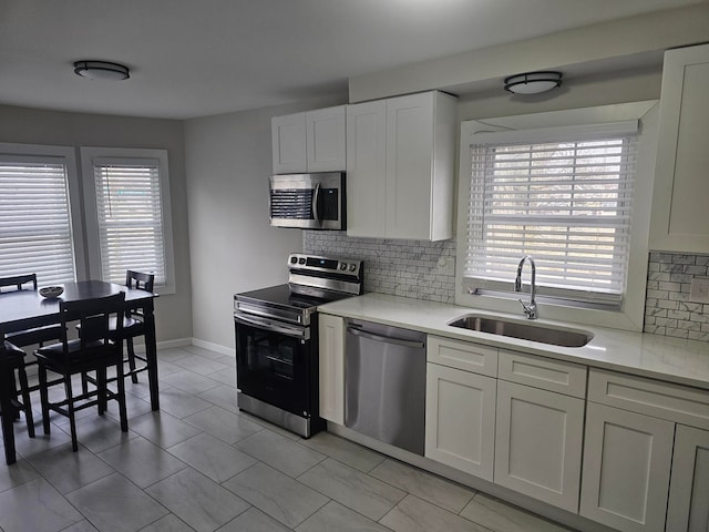 kitchen featuring white cabinetry, a healthy amount of sunlight, stainless steel appliances, and sink