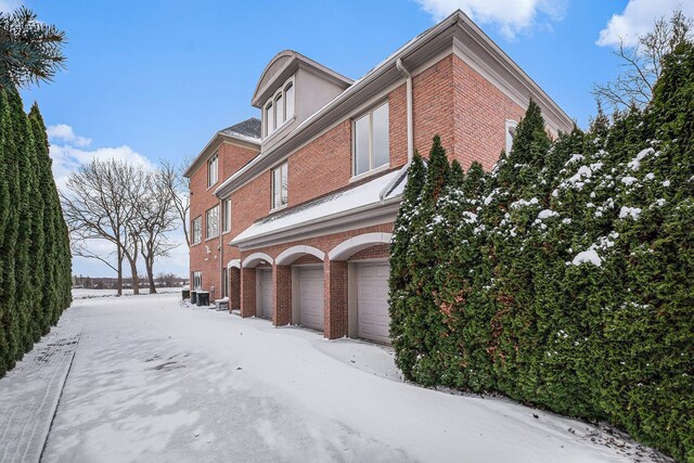 view of snow covered exterior featuring a garage