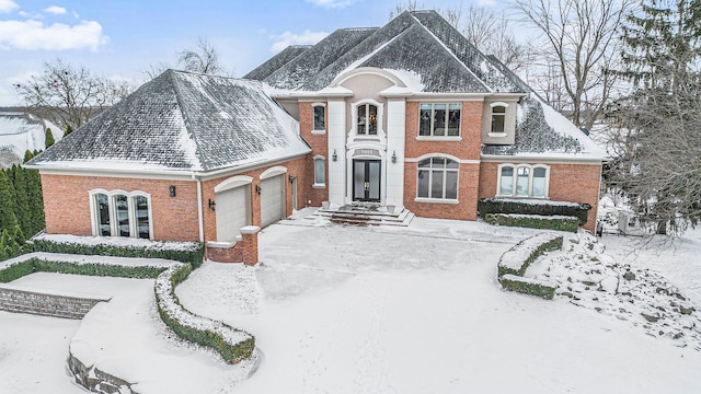 view of front of home featuring driveway, brick siding, and an attached garage