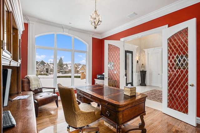 office space featuring light wood-style flooring, visible vents, a chandelier, and ornamental molding