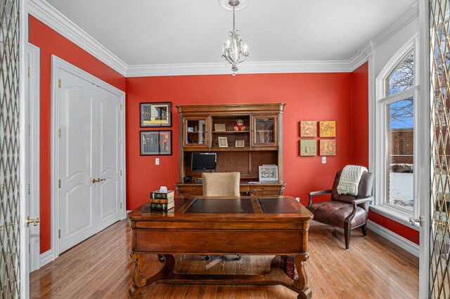 office area with crown molding, a healthy amount of sunlight, light wood-style floors, and baseboards