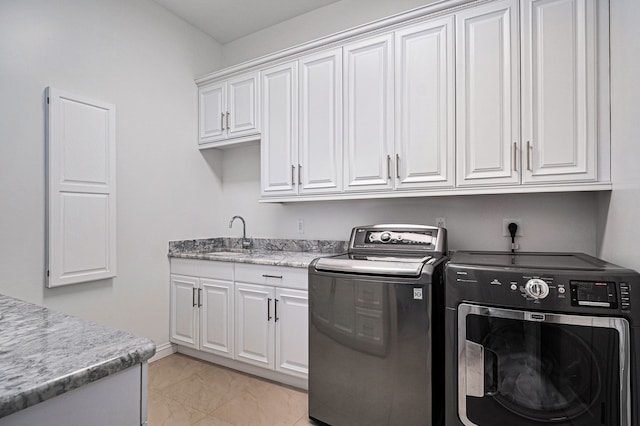 washroom with washer and clothes dryer, cabinets, light tile patterned floors, and sink