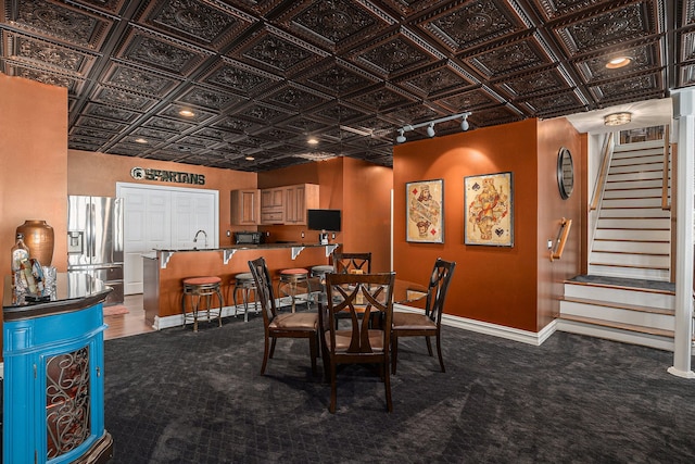 carpeted dining room with stairway, baseboards, and an ornate ceiling