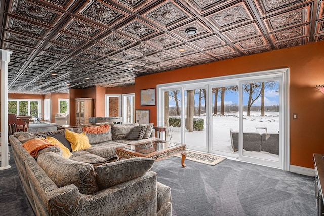 living area with baseboards, an ornate ceiling, and carpet floors