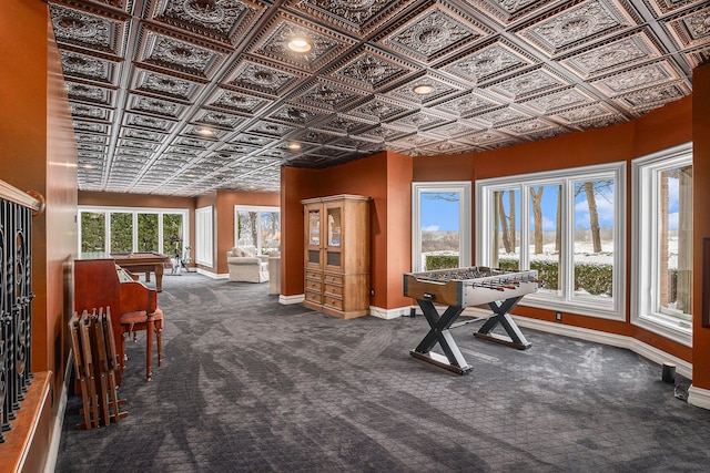 rec room featuring carpet flooring, an ornate ceiling, and baseboards