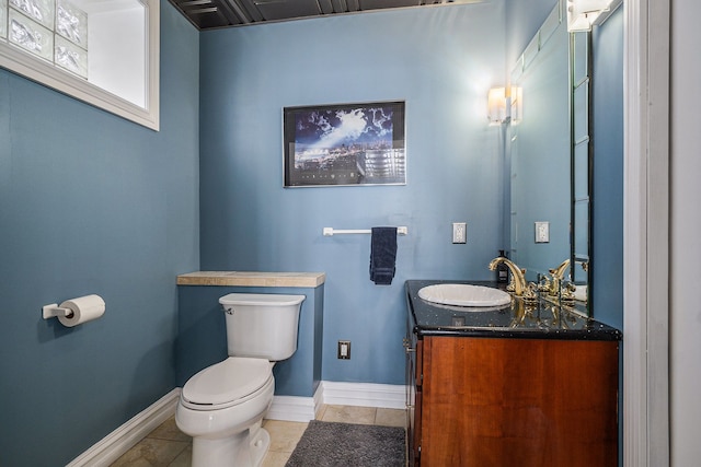 bathroom with tile patterned flooring, toilet, vanity, and baseboards