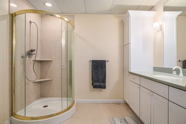 bathroom with an enclosed shower, vanity, a drop ceiling, and tile patterned flooring