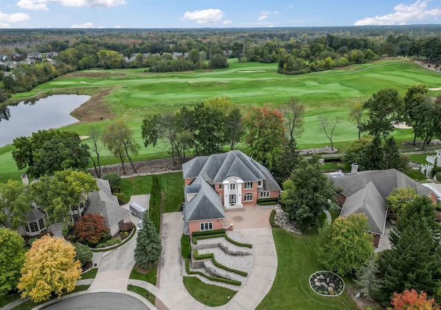 birds eye view of property with golf course view and a water view