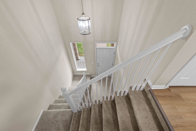 stairway with a notable chandelier