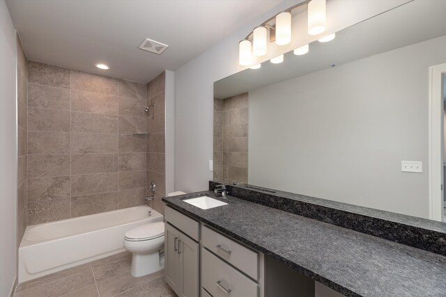 full bathroom with vanity, tiled shower / bath combo, toilet, and tile patterned flooring