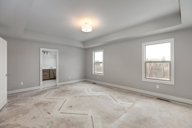 unfurnished room with a tray ceiling