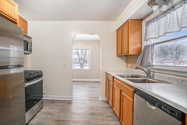 kitchen with sink, stainless steel appliances, and hardwood / wood-style flooring