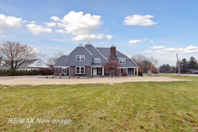 rear view of property featuring a lawn