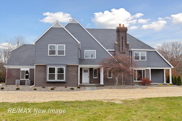 60 Golfview Dr, Saginaw, MI 48638 - view of front of house with brick siding, a chimney, a front lawn, and roof with shingles