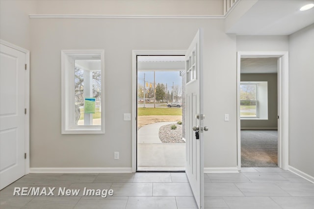 carpeted entryway with a wealth of natural light