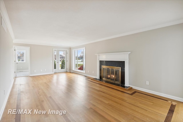 unfurnished living room featuring french doors, light hardwood / wood-style flooring, and ornamental molding