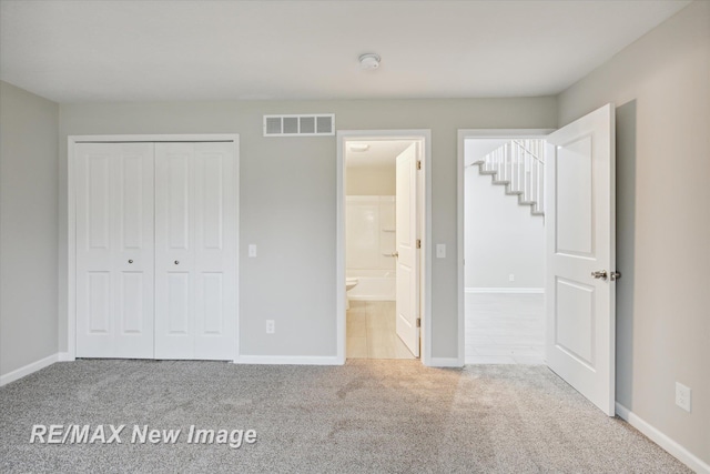 unfurnished bedroom with a closet and carpet floors