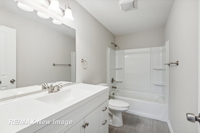 full bathroom with hardwood / wood-style floors, vanity, shower / bath combination, and toilet