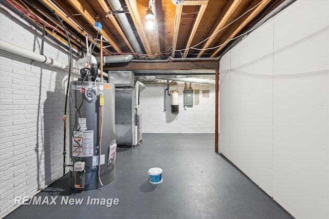 basement with heating unit, water heater, electric panel, and brick wall