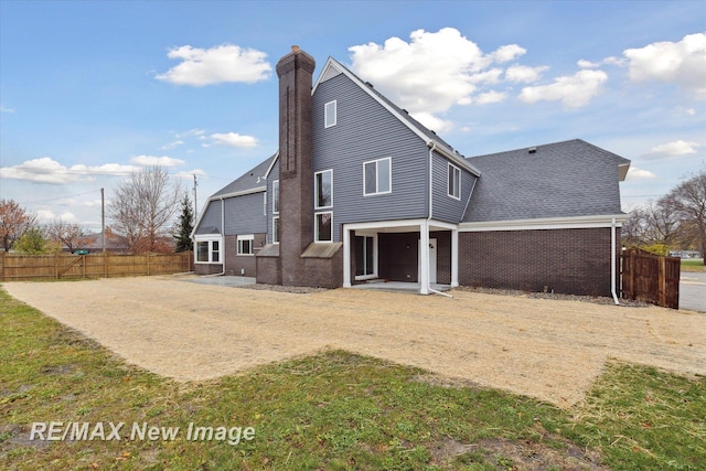 60 Golfview Dr, Saginaw, MI 48638 - rear view of property featuring a chimney, a patio area, and brick siding