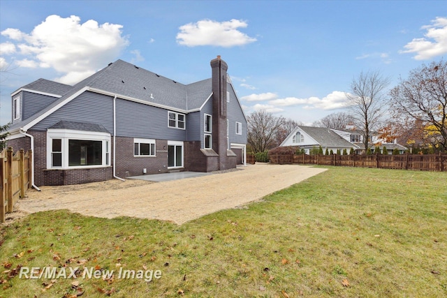 rear view of house with a yard and a patio