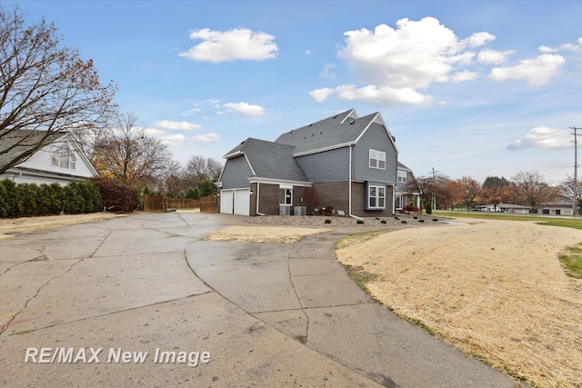 60 Golfview Dr, Saginaw, MI 48638 - back of house featuring brick siding, driveway, and a garage