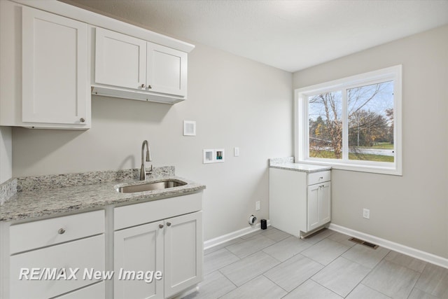 laundry area with cabinets, hookup for a washing machine, and sink