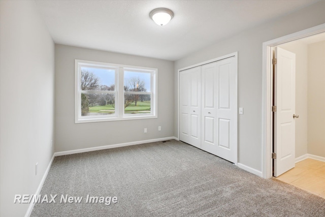 unfurnished bedroom featuring light colored carpet and a closet