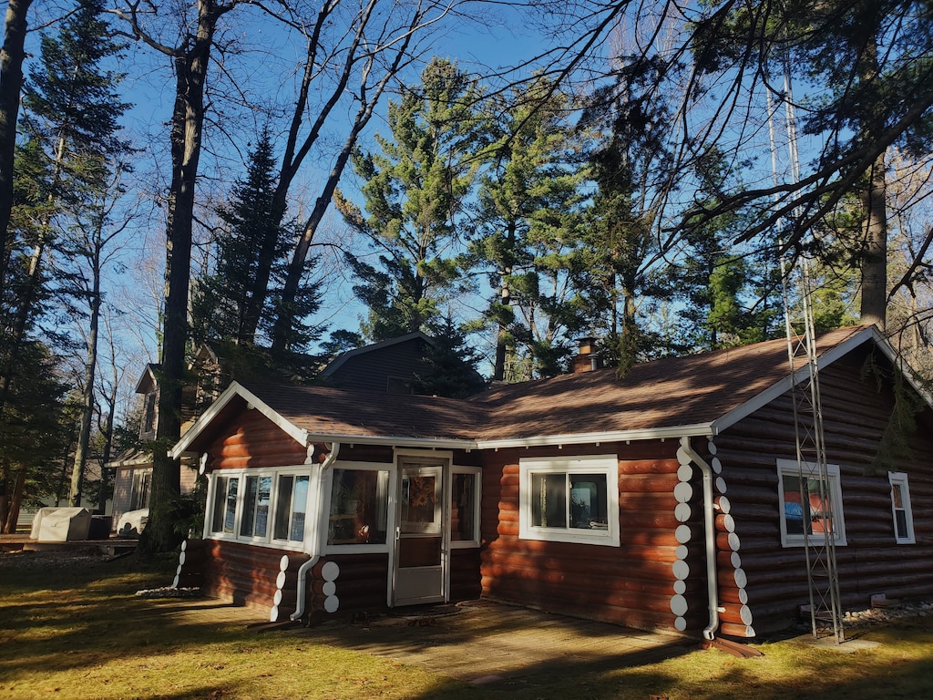 rear view of house with a yard and a sunroom