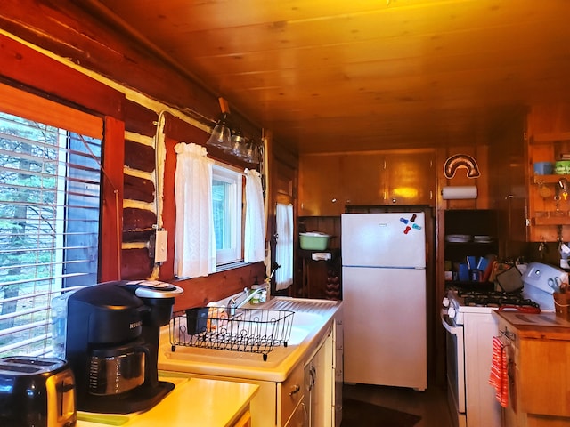 kitchen featuring wood ceiling, a healthy amount of sunlight, and white appliances