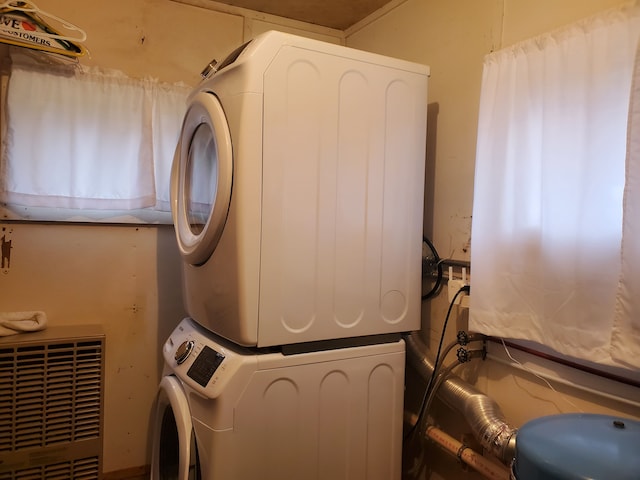 clothes washing area featuring stacked washing maching and dryer