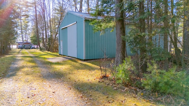 view of outdoor structure featuring a lawn and a garage