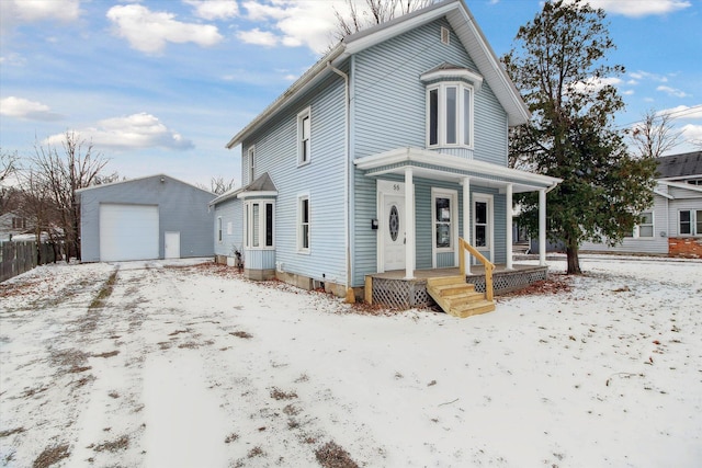 view of front property with a porch, a garage, and an outbuilding