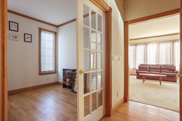 interior space featuring french doors, ornamental molding, and light wood-type flooring